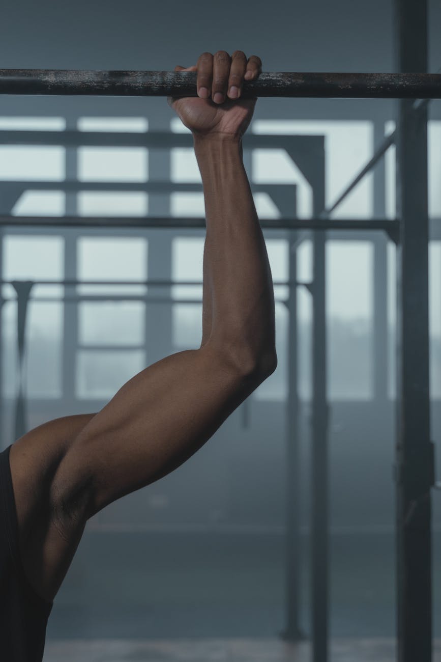 Close-up of a man's hands gripping a pull-up bar, showing determination.