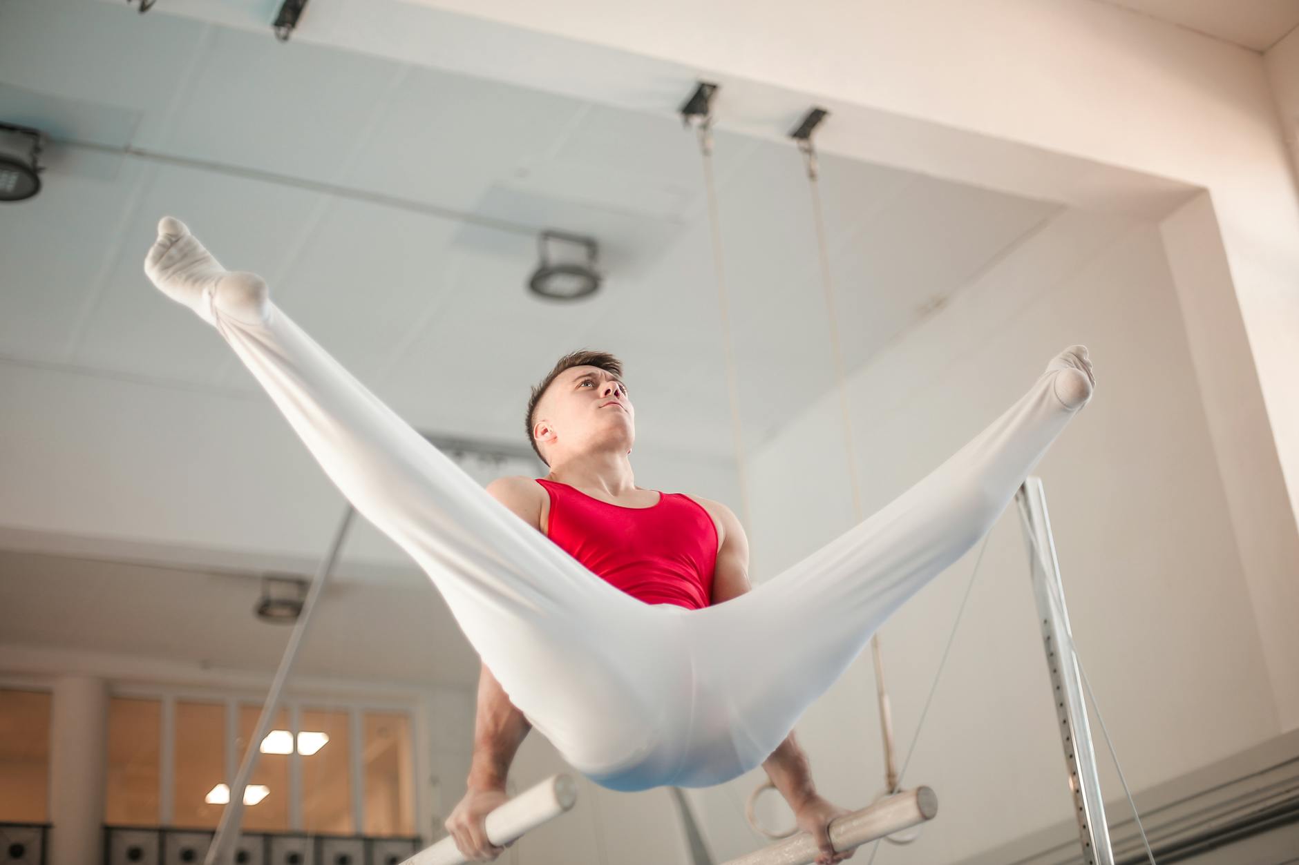 Man performing a controlled bodyweight exercise in a minimalist gym setting.