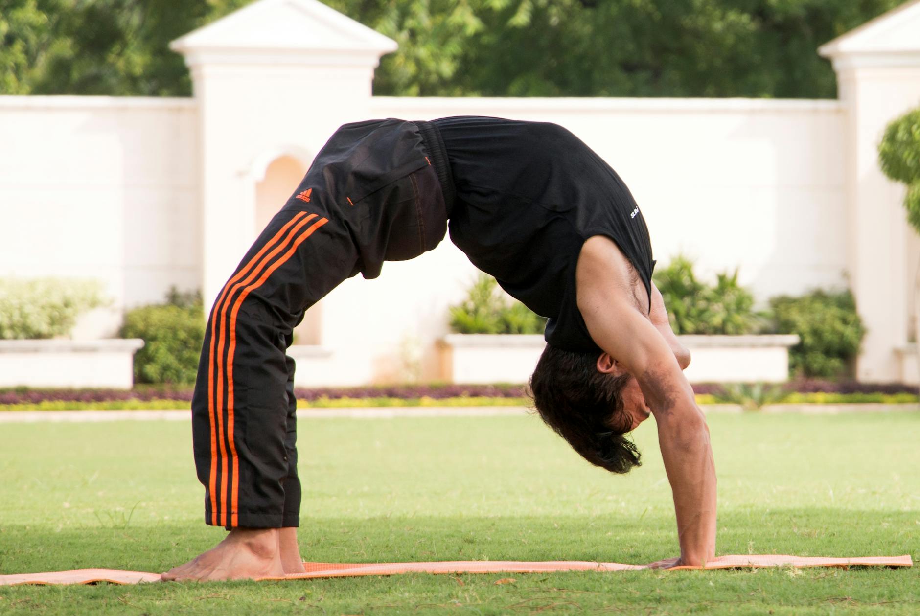 Side view of a man during a dynamic stretching movement.